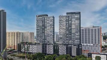Um complexo de edifícios residenciais altos, com vários prédios de apartamentos, cercado por áreas verdes e um céu limpo.