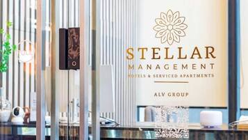 Bancada de recepção com logotipo da Stellar Management, indicando um hotel ou apartamento para serviços.
