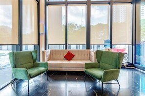 A room with a sofa and two armchairs, large windows, and a black floor. - Urban Suites by Stellar ALV (Jelutong)