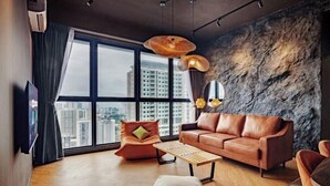 Un soggiorno moderno con una grande finestra, un divano in pelle, un tavolino in legno e una parete decorata con pietra.