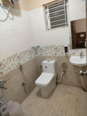A compact bathroom with a toilet, bidet, and sink. - Golden Chariot (Bengaluru)