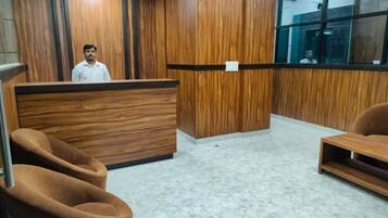 A reception area with a wooden reception desk, plush seating, and a marble floor.