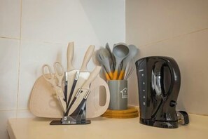 A kitchen counter with a knife block, a mug with utensils, and a coffee maker. - Studio Zen@Midhills Genting Highlands (Free WiFi) (Genting Highlands)
