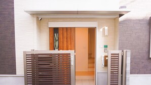 En hotellentrén med en träport, en synlig dörr och en skylt som visar att det är rum nummer 16–2.