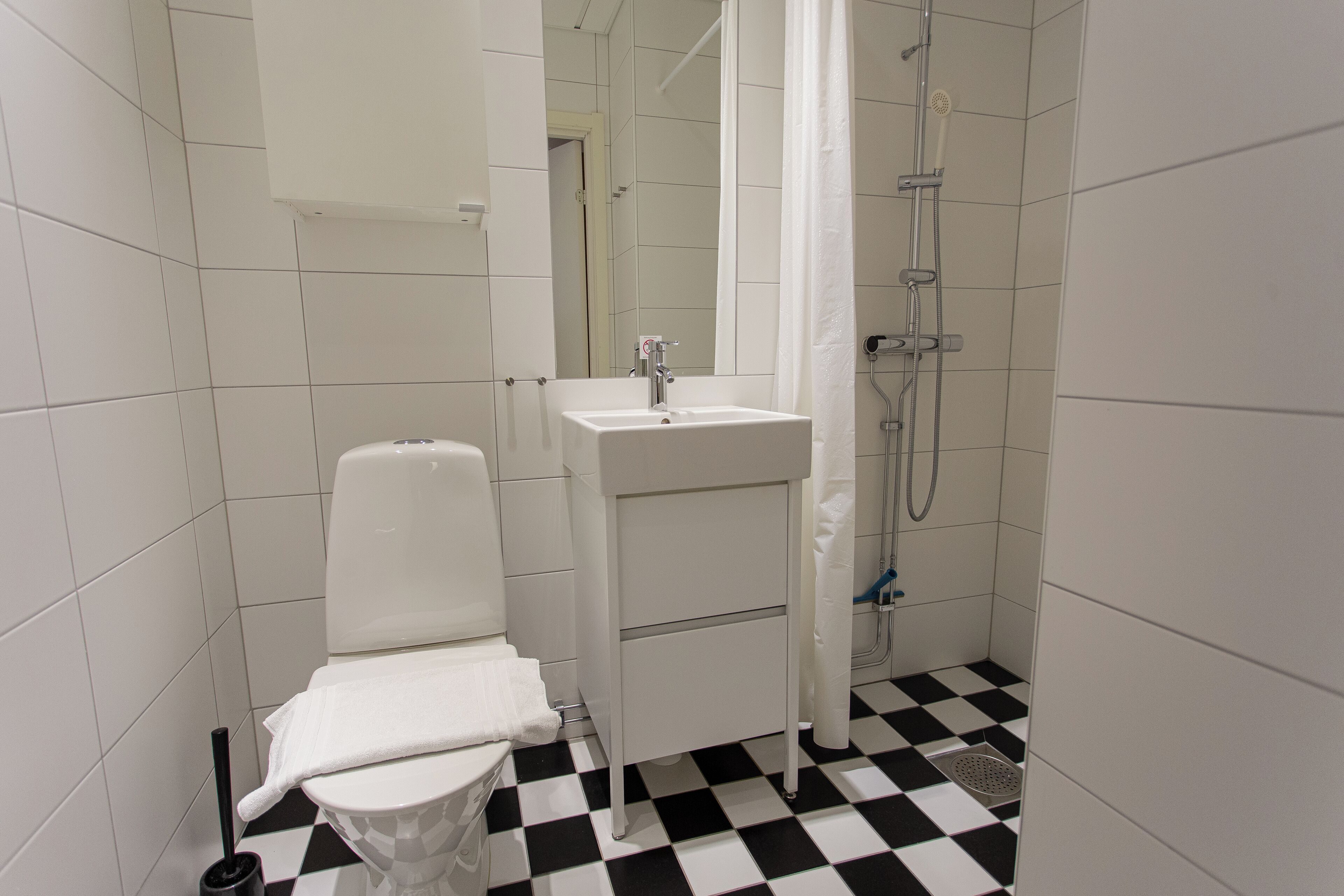 A bathroom with a toilet, sink, and shower.