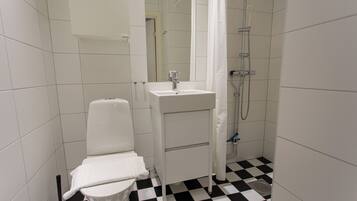 A bathroom with a toilet, sink, and shower.