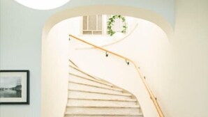 A staircase with a wooden handrail and a simple, clean design.