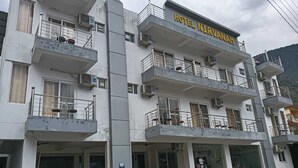 A multi-story hotel with balconies and air conditioning units. - Hotel Nirvanam (Chamoli)