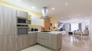 Una cucina moderna con elettrodomestici integrati, un'isola centrale e un'area pranzo con tavolo e sedie.