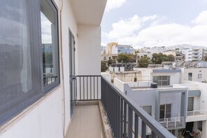 A balcony with a view of modern buildings and a clear sky. - St.Julians apartment (San Gwann)