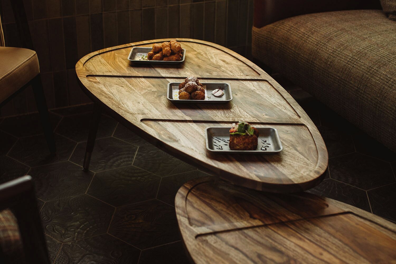 A wooden table with three dishes of food.