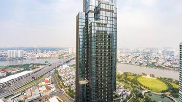 A high-rise building with a modern glass facade, surrounded by a river and a mix of residential and commercial buildings.