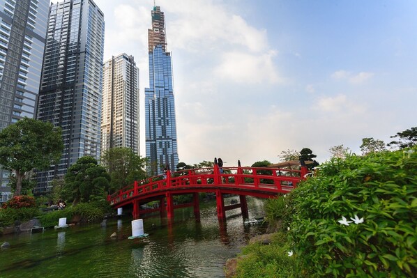 Un puente rojo sobre un cuerpo de agua, con edificios altos al fondo.
