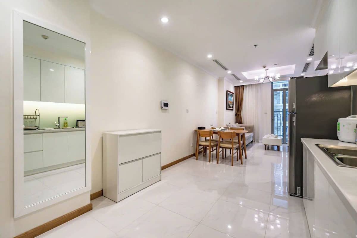 A modern kitchen with a dining area, a built-in oven, and a large mirror.
