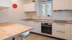 A modern kitchen with a wooden countertop, white cabinets, a built-in oven, and a window with a view of buildings. - Beautiful apartment for 6 guests with TV and patio (Arco)