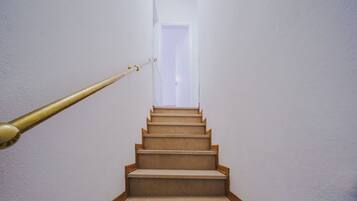 Eine Treppe mit Handlauf führt zu einer Tür oben.