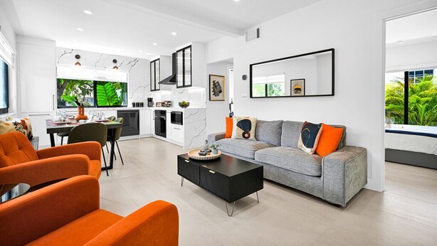 A modern living room with a grey sofa, orange chairs, and a black coffee table. - Calm Miami Oasis -Secluded Patio (Miami)
