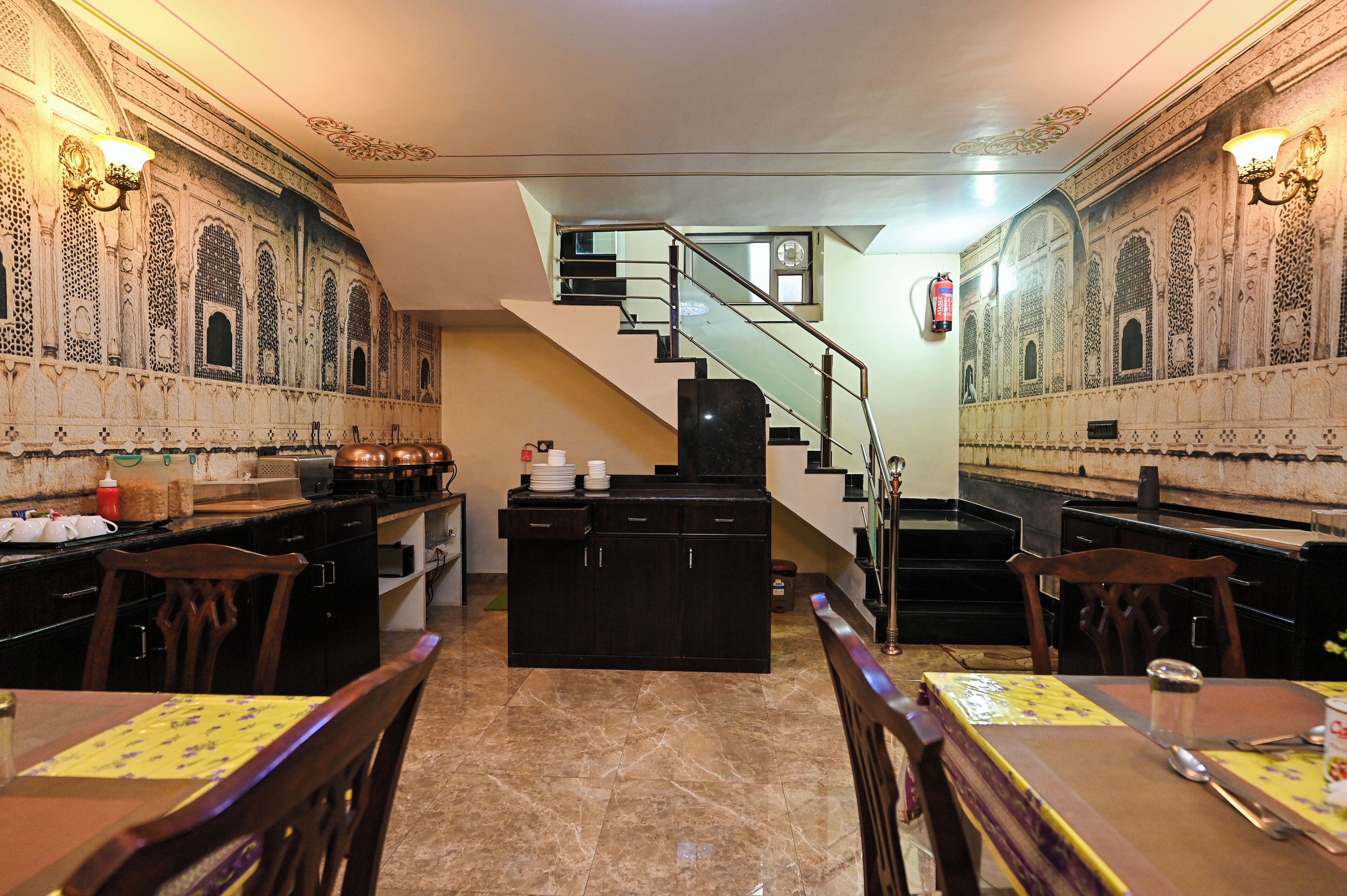 Un interior tradicional con una escalera, una zona de cocina y mesas de comedor.