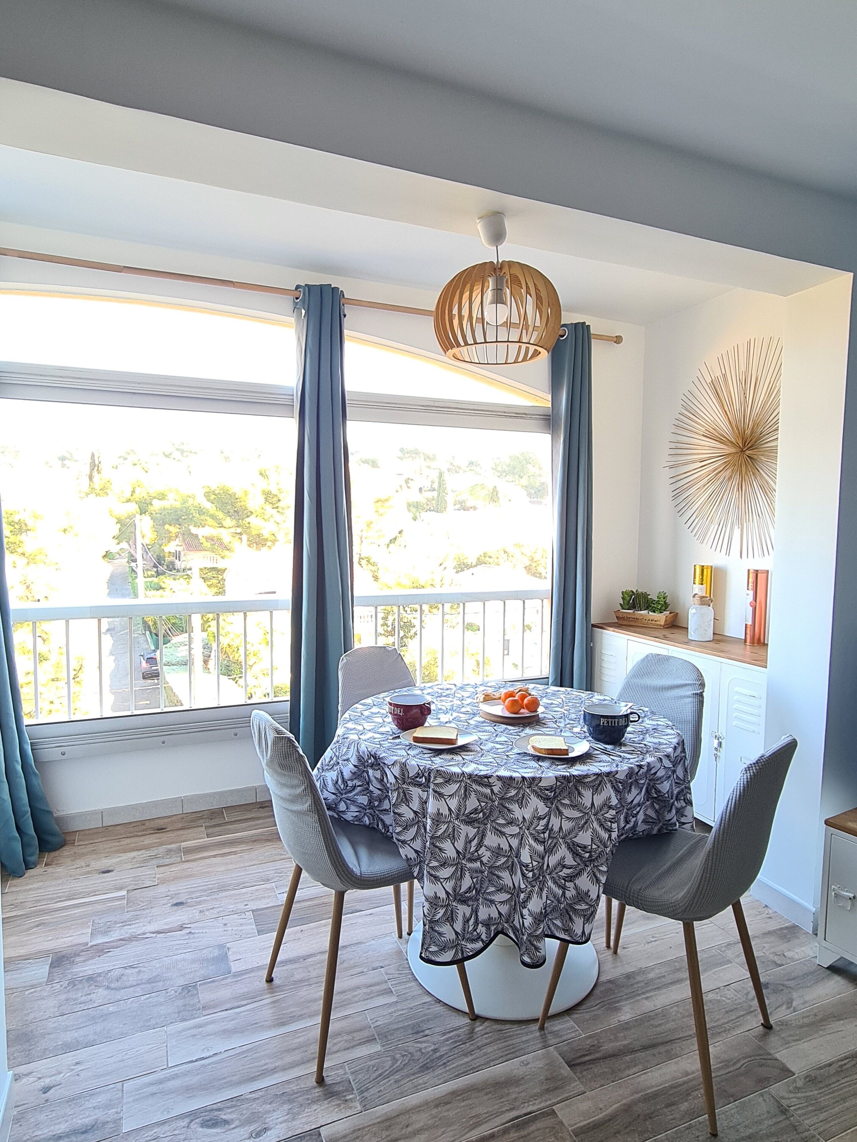 A dining area with a round table, chairs, and a view of the outdoors.