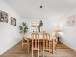 A dining area with a round table, six chairs, a hanging light fixture, and artwork on the walls. - "Agla" - 2.5km from the sea by Interhome (Nørre Nebel)
