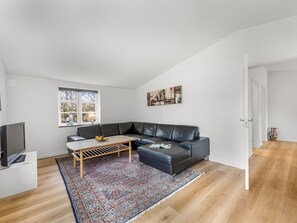 A modern living room with a black leather sofa, a wooden coffee table, and a colorful rug. - "Agla" - 2.5km from the sea by Interhome (Nørre Nebel)