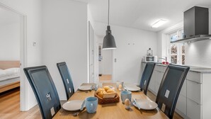 A modern kitchen with white cabinets, a microwave, and a hanging pendant light. - "Agla" - 2.5km from the sea by Interhome (Nørre Nebel)