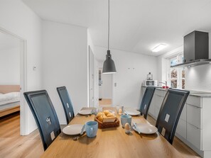 A modern kitchen with white cabinets, a microwave, and a hanging pendant light. - "Agla" - 2.5km from the sea by Interhome (Nørre Nebel)