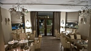 Un salón espacioso con chimenea, asientos cómodos y vistas al exterior.