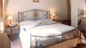 A bedroom with a bed, two bedside tables, a lamp, and a framed picture on the wall. - Villa Panconesi (Montespertoli)