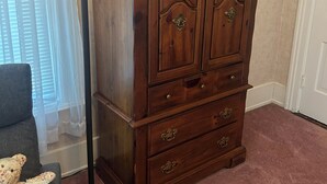 Une commode en bois avec des tiroirs et une lampe placée à côté.