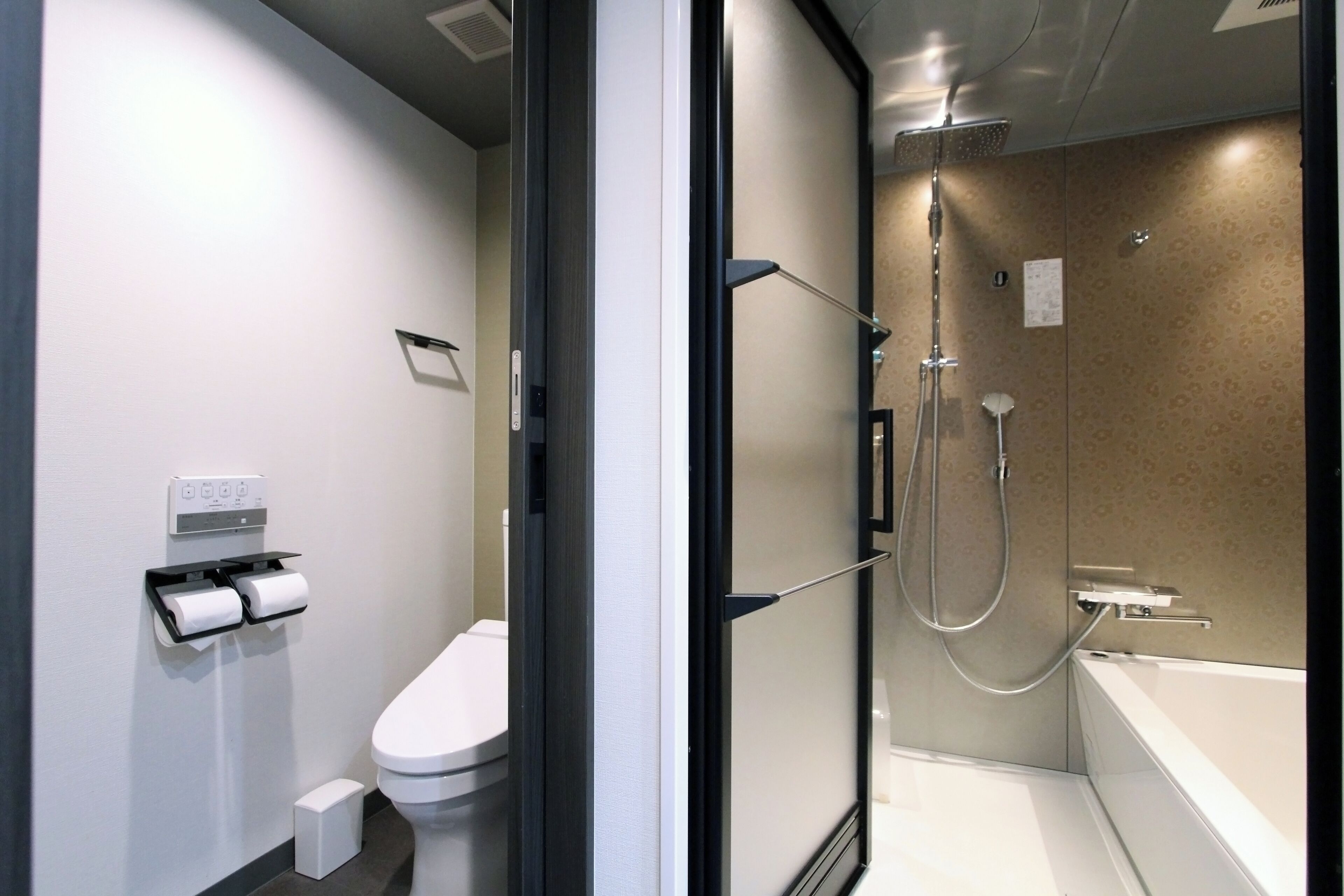 A modern bathroom with a toilet, a shower, and a bathtub.