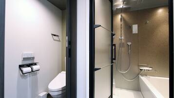 A modern bathroom with a toilet, a shower, and a bathtub.
