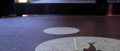 A tiled floor with a cat silhouette and circular patterns.