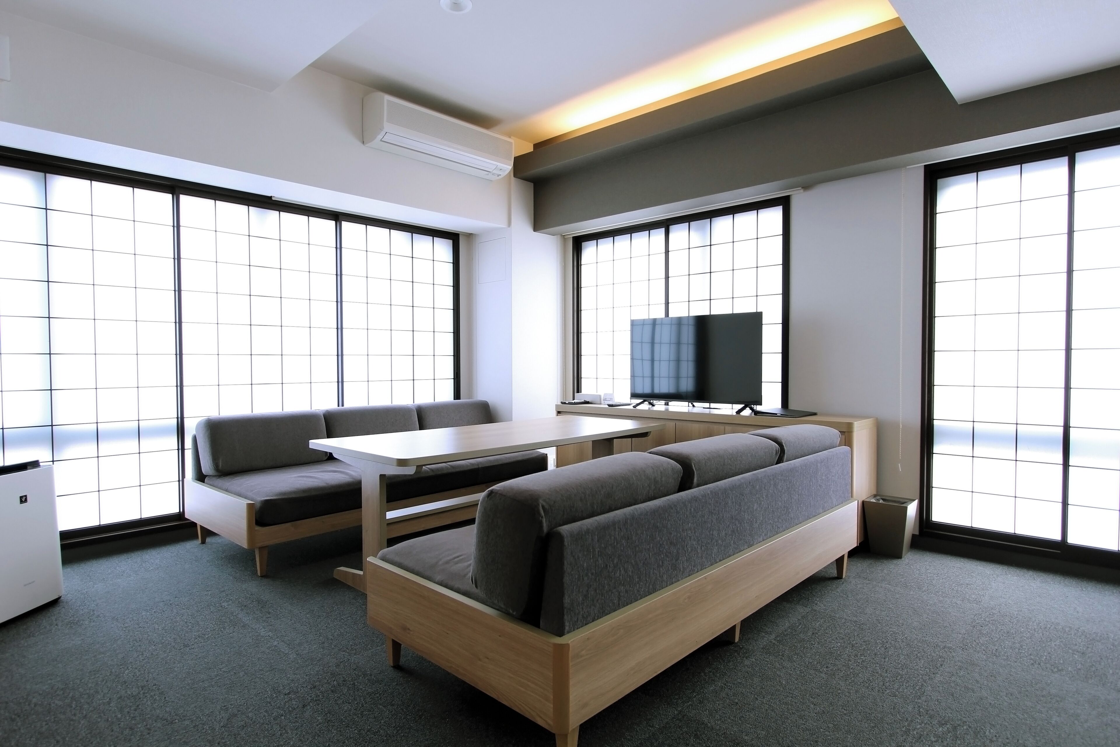 A modern room with a sofa, a small table, and a TV.