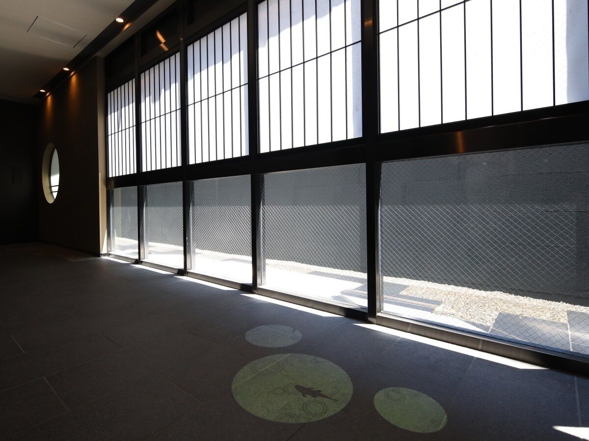 A spacious hallway with large windows and a circular skylight.