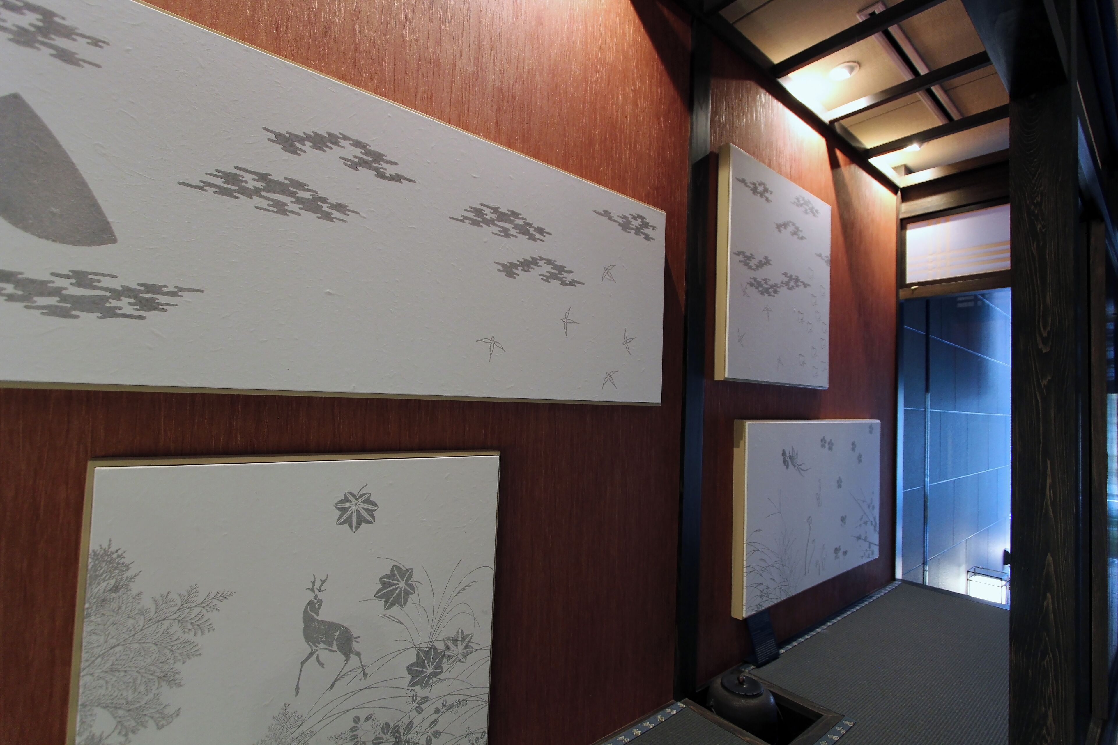 A hallway with wooden paneling and artwork on the walls.