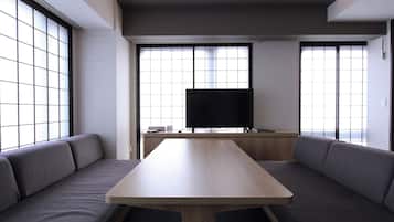 A modern room with a wooden table and grey upholstered seating.