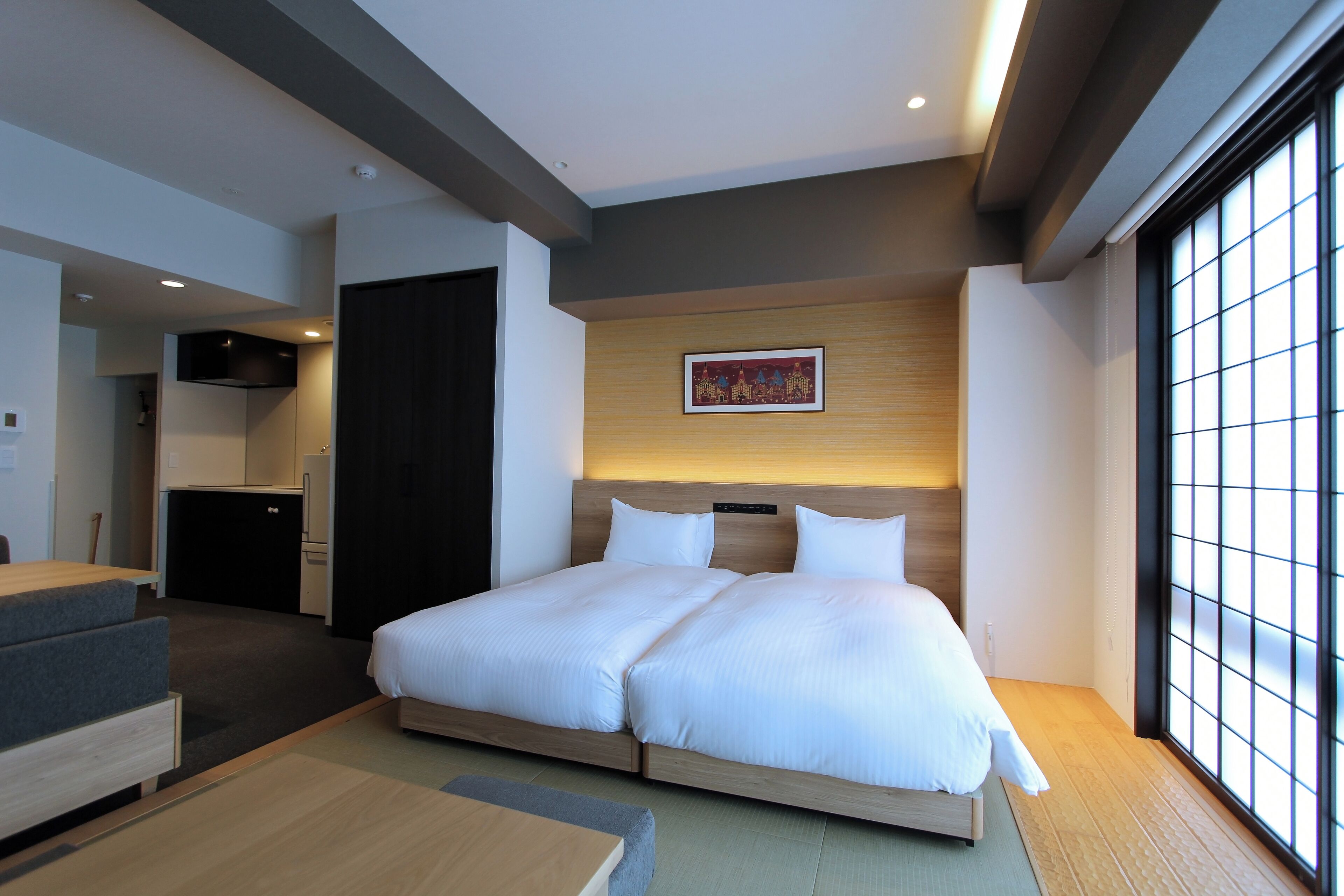Een moderne hotelkamer met een groot bed, een kleine kitchenette en een eethoek.