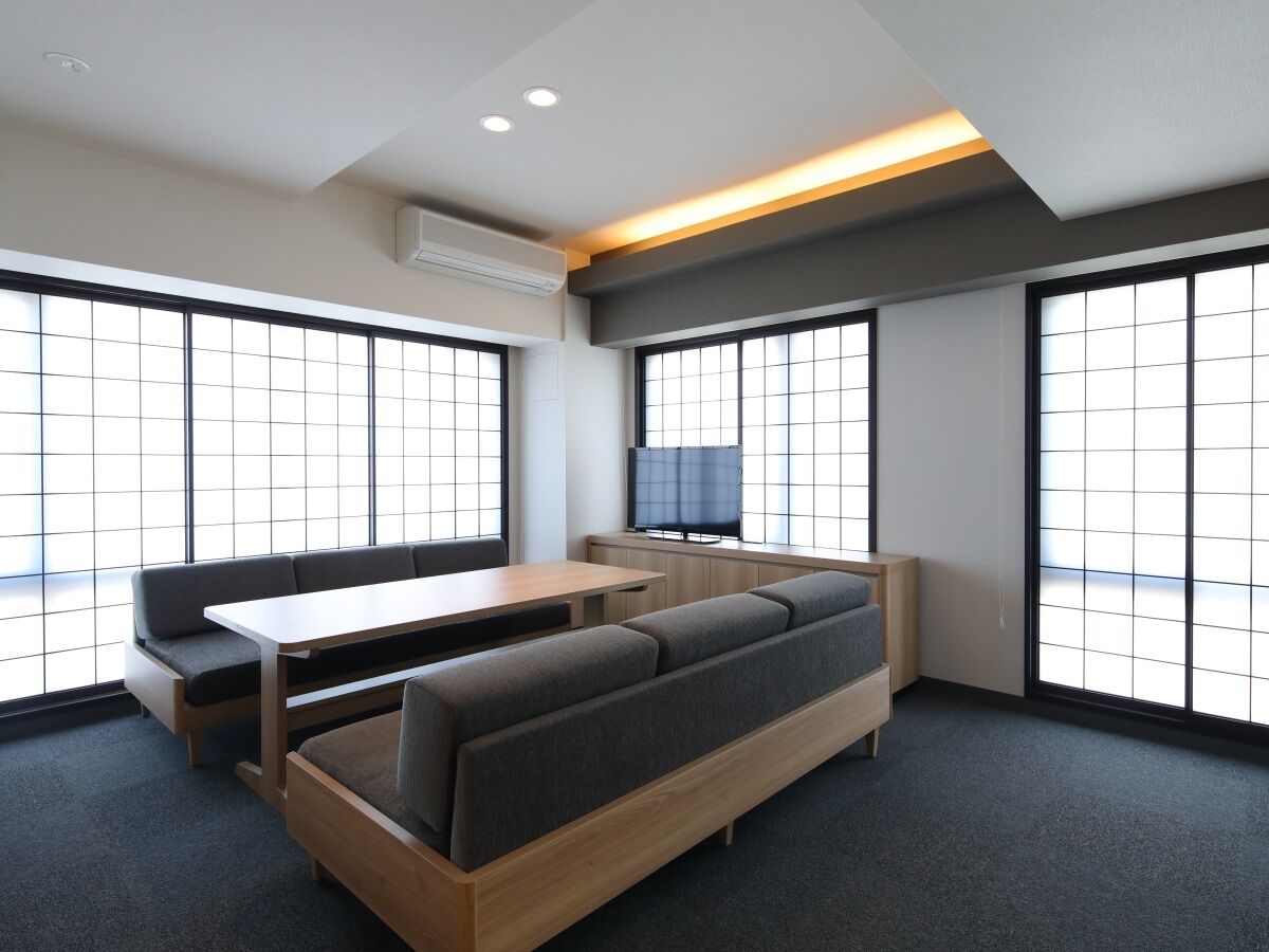 Una habitación moderna con sofá, mesa y televisor.