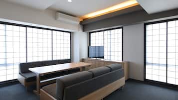 Una habitación moderna con sofá, mesa y televisor.