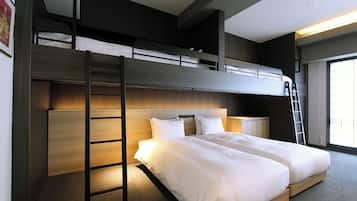 A bunk bed room with a ladder, a bedside table, and a window with blinds.
