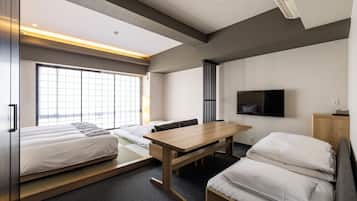 A modern hotel room with a bed, a desk, a TV, and a large window.