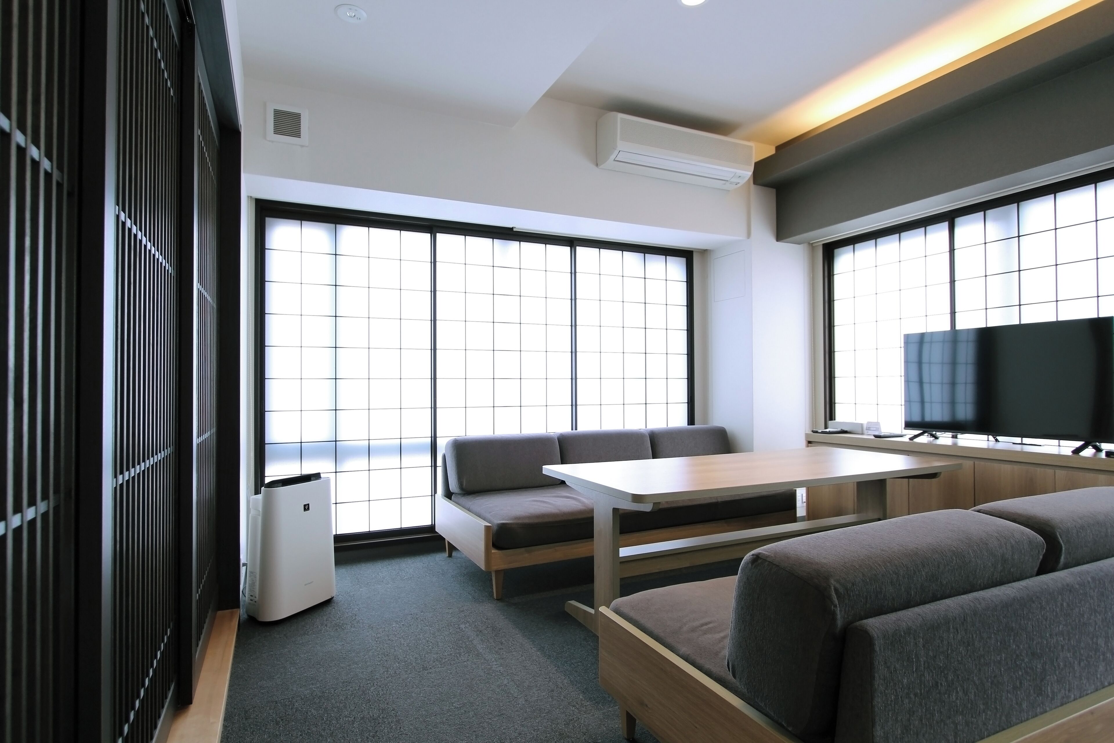 A modern room with a sofa, a table, and a TV.