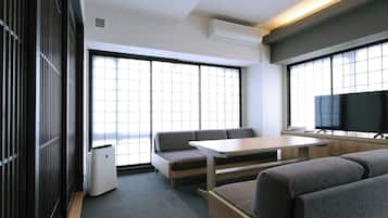 A modern room with a sofa, a table, and a TV.