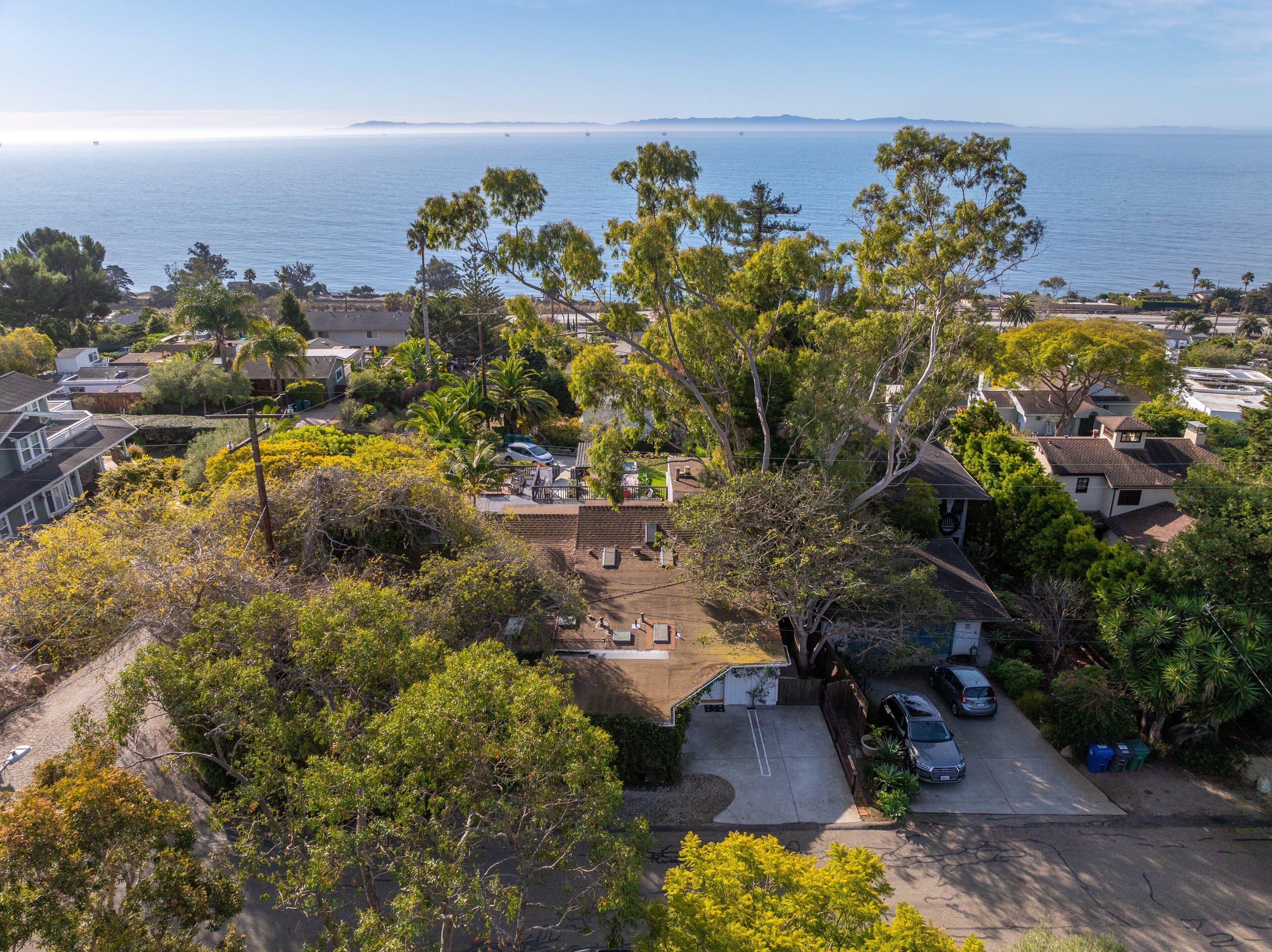 Un barrio residencial con casas, árboles y vista al océano.