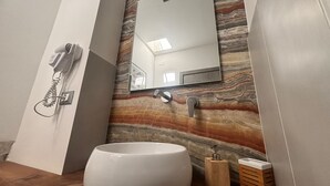 A bathroom with a marble wall, a sink, a mirror, a hairdryer, and a telephone. - Yllen Rooms (Large Double Room) (Avola)