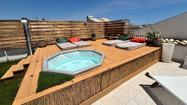 A rooftop terrace with a hot tub, lounge chairs, and a wooden deck. - Yllen Rooms (Large Double Room) (Avola)