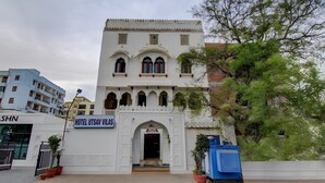 A white building with a sign reading "HOTEL UTSAV VILAS". - Utsav Vilas (Jaipur)