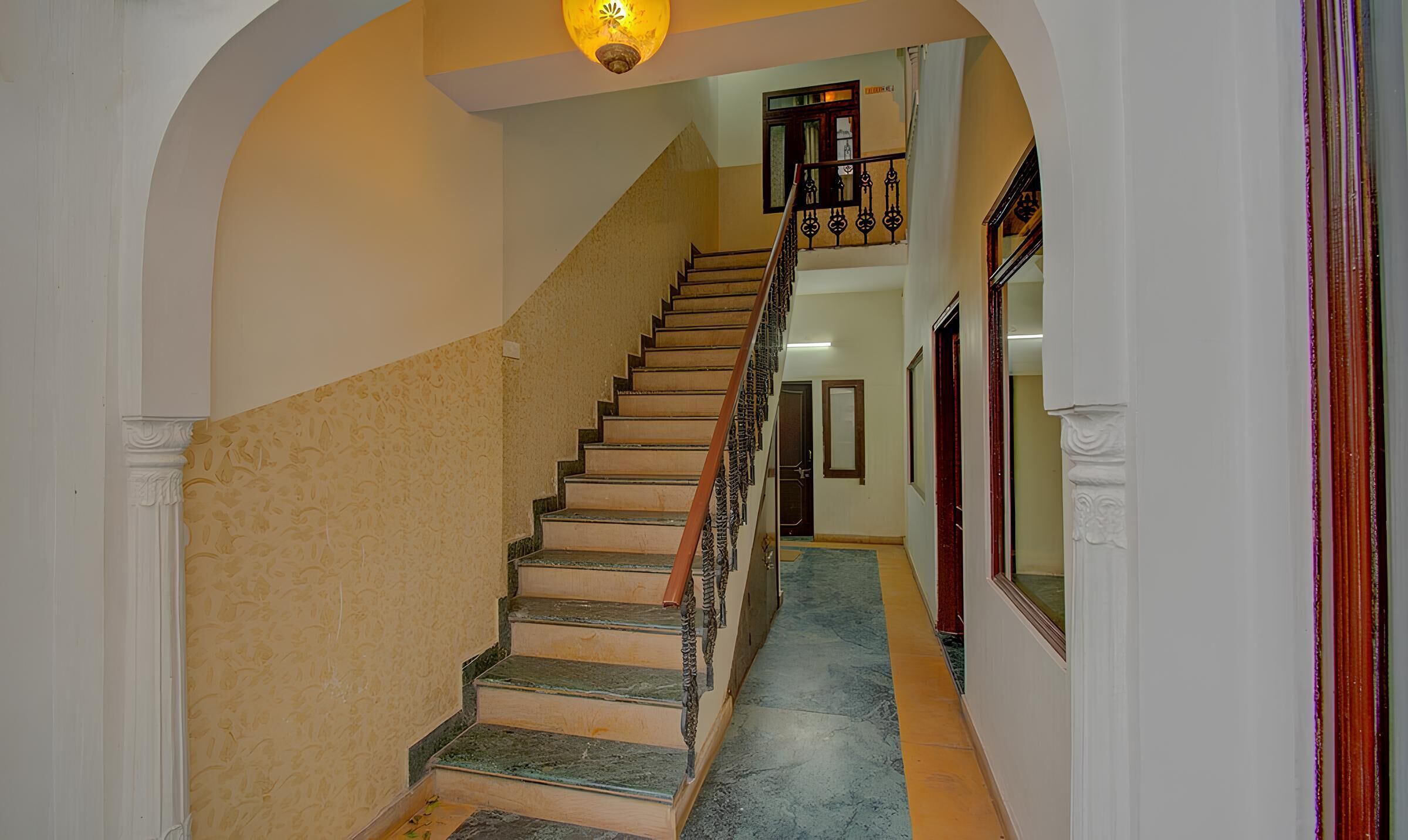 A staircase with a handrail, leading to a landing with a light fixture.