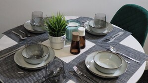A round dining table set with plates, bowls, cutlery, glasses, and a potted plant. - Luxury Urban Escape Near Nec, Airport, Hs2 (Birmingham)